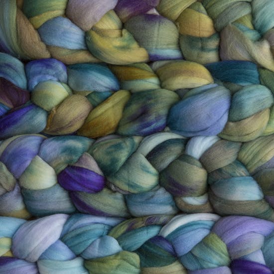 Color 416 Indiecita. A handyed merino top with shades of cornflower, bluebell, sage green, lavender, light cyan, and violet.