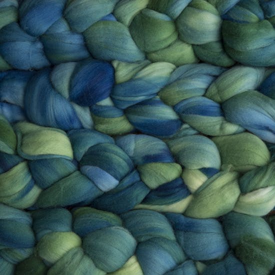 Color 033 Cereza. A handyed merino top with shades of leaf green, ocean blue, sky blue, and deep emerald. 