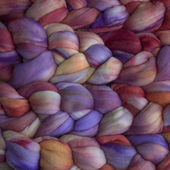 Color 850 Archangel. A handyed merino top with shades of light and dark violet, ruby, yellow, and orange.