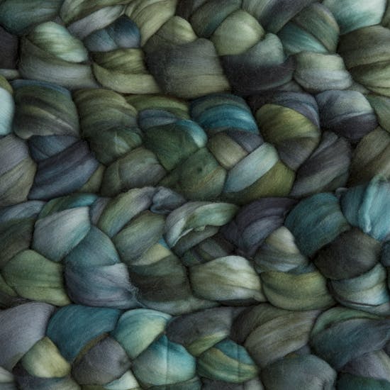 Color 855 Aguas. A handyed merino top with shades of forest, moss, and leaf green.
