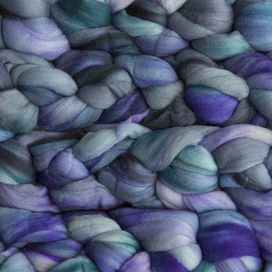 Color 856 Azules. A handyed merino top with shades of violet, lavender, cyan, charcoal, and grey.