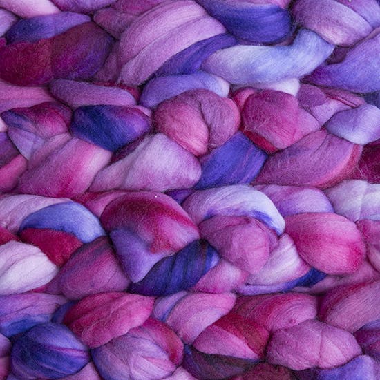 Color 865 Baya Electrica. A handyed merino top with shades of maroon, magenta, lavender, violet, and fuschia.