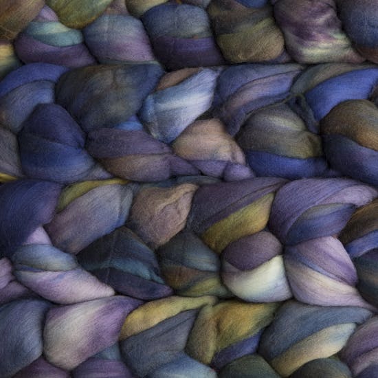 Color 870 Candombe. A handyed merino top with shades of storm blue, true blue, lavender, leaf green, cyan, and purple grey.