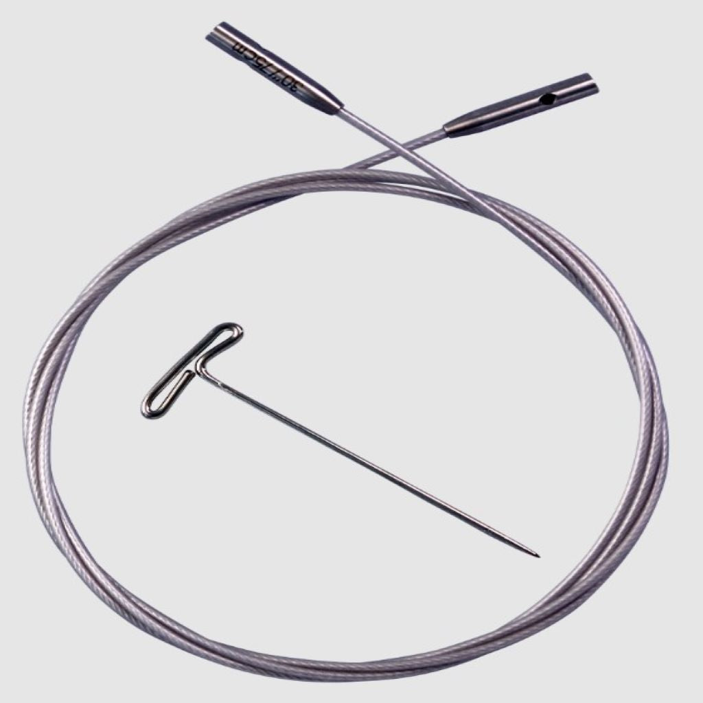 A silver ChiaoGoo SWIV360 cable rolled into a circle with a silver t-pin in the center of the cable