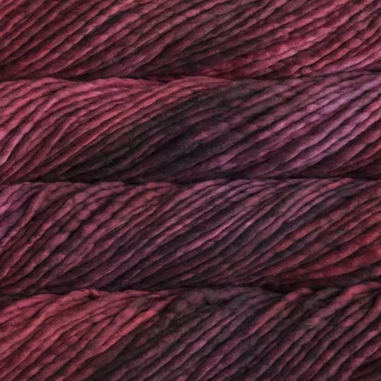 Color: Stitch Red 873. A deep red and black variegated variant of Malabrigo Rasta yarn. 