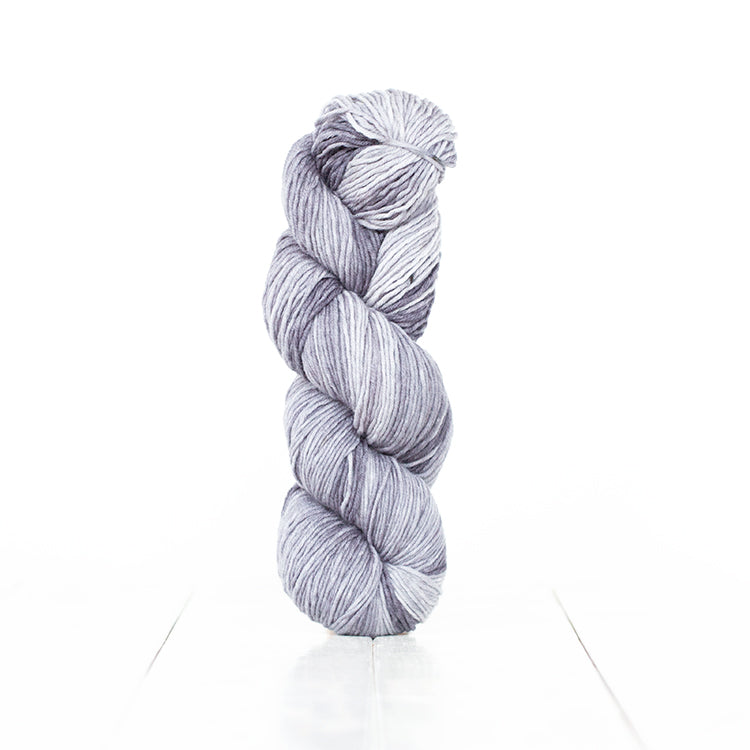 Color 6064, a variegated monochromatic skein of cool toned light grey yarn.