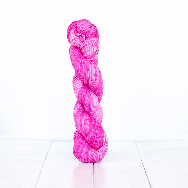 1211, a bright fuschia pink skein of Urth Yarn's hand-dyed Monokrom Cotton DK weight yarn.