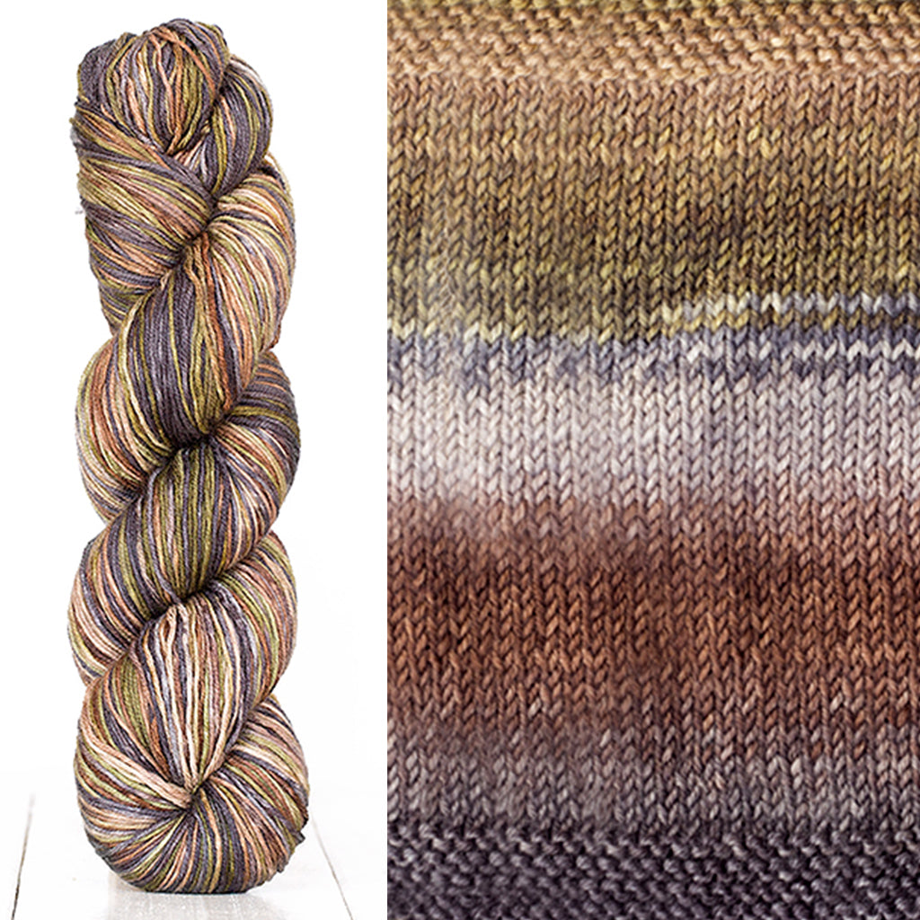 Color 3006: a hand-dyed skein of self striping wool yarn with brown, white, grey, and tan shades
