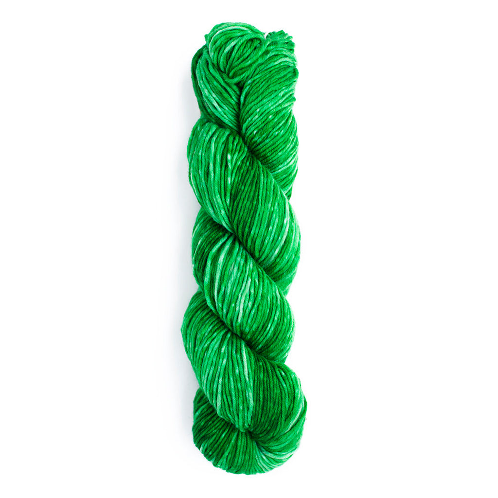 A skein of Monokrom Worsted, color 4058,  a bright, tonal emerald green.