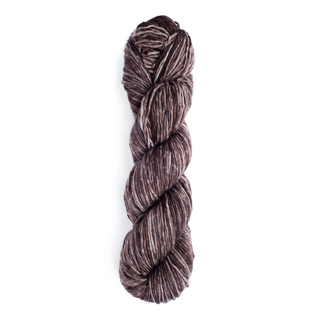 A skein of Monokrom Worsted, color 4061, a dark, tonal, warm grey.