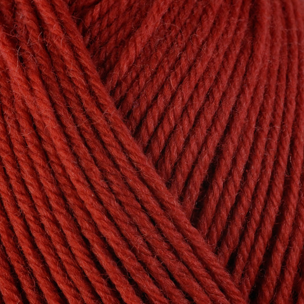 Kabocha 3327, a red-orange skein of washable worsted weight Ultra Wool yarn.