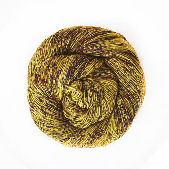 Malabrigo Mechita Aureo Yarn - a yellow yarn speckled with brown