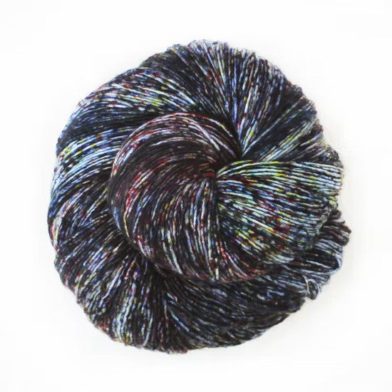 Malabrigo Mechita New Moon Trio Yarn - a heavily speckled yarn with black, red, blue and yellow