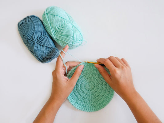 person using pretty blue yarn to learn how to join yarn in crochet