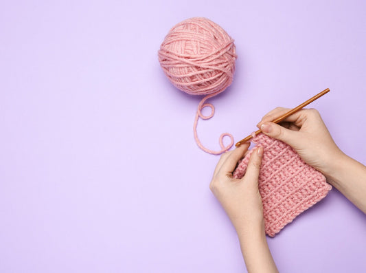woman crocheting using the best yarn for crochet in a pink color
