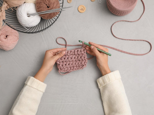 woman holding her project out as she learns how to hold crochet yarn