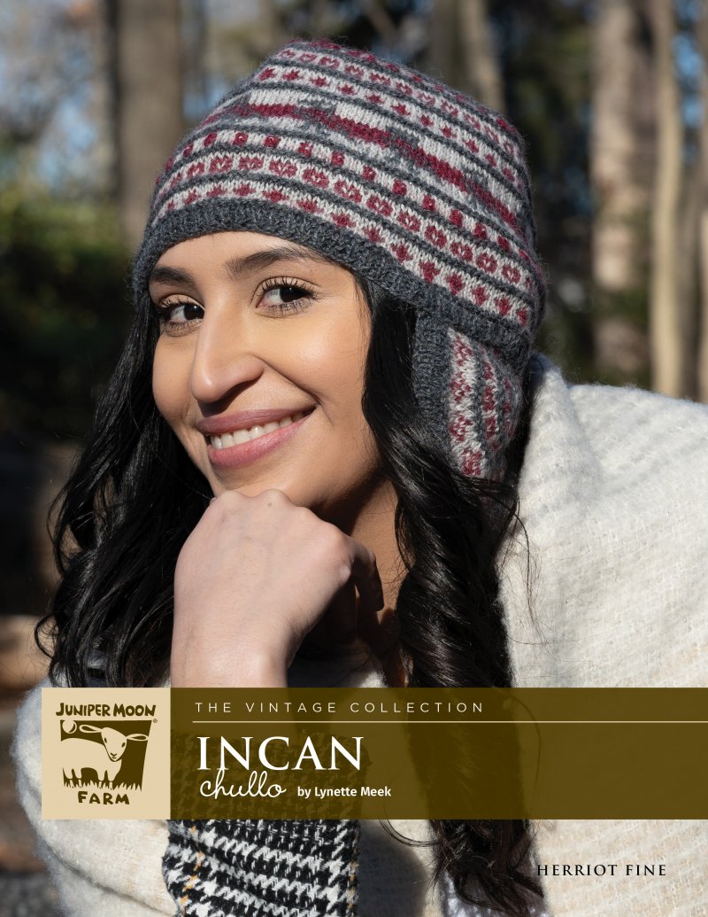 Woman smiling, wearing a patterned knit hat.