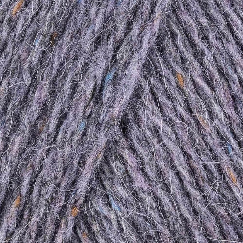 Amethyst 192: A heathered tweed yarn in a dusty purple grey color with flecks of brown and blue.
