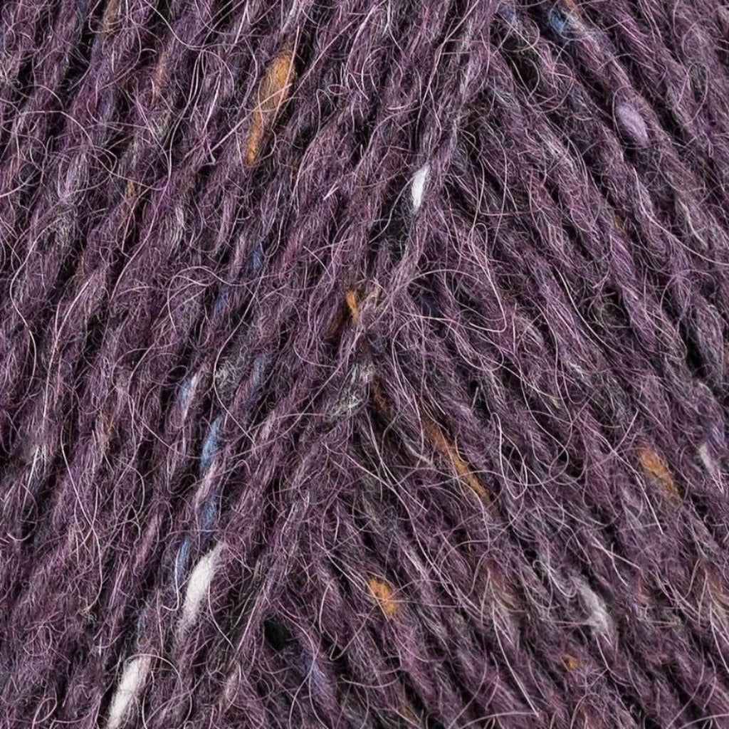 Bilberry 151: A heathered tweed yarn in a medium dusty purple color with flecks of orange and white.