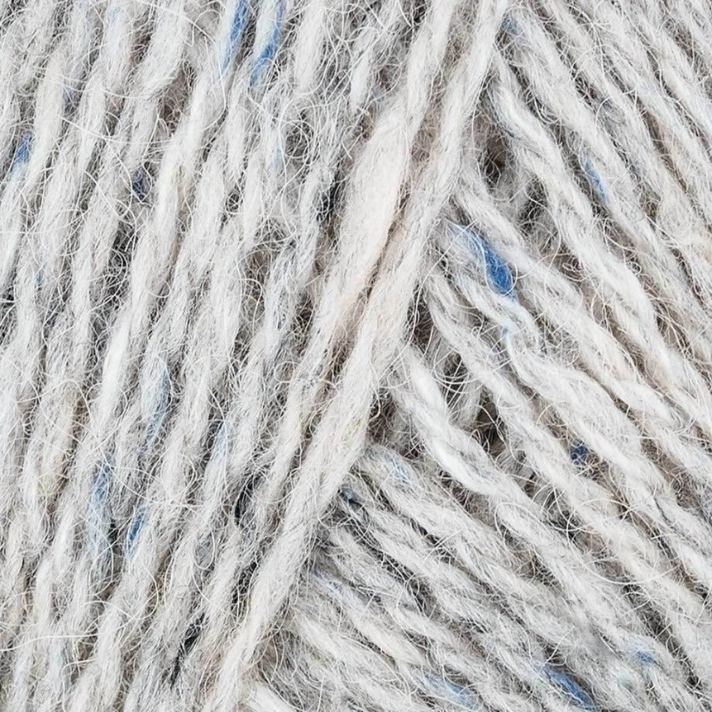 Clay 177: A heathered tweed yarn in a creamy white with flecks of blue