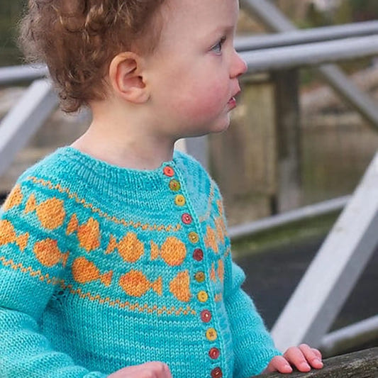 Toddler in Goldfish sweater looking off to the side