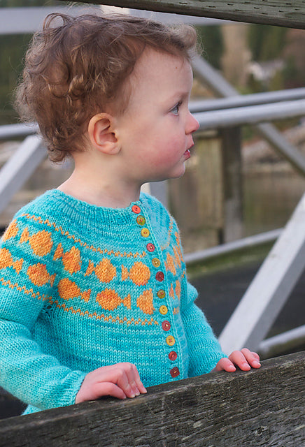 Toddler in Goldfish sweater looking off to the side