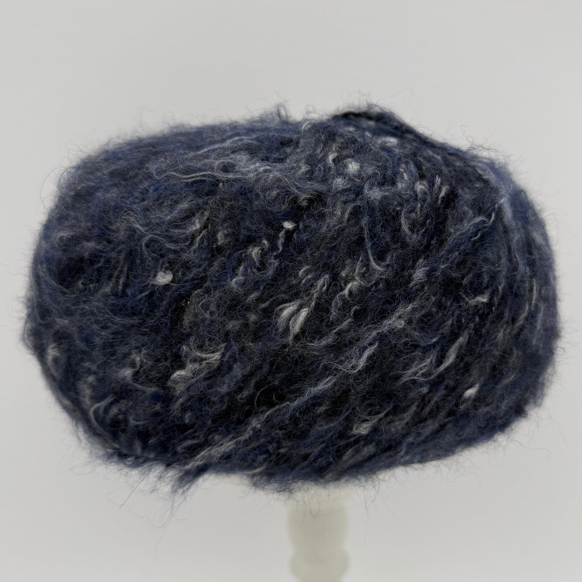 Mirasol Rit'i Aran Yarn color 06 Midnight Shadow, navy ball with white flecks