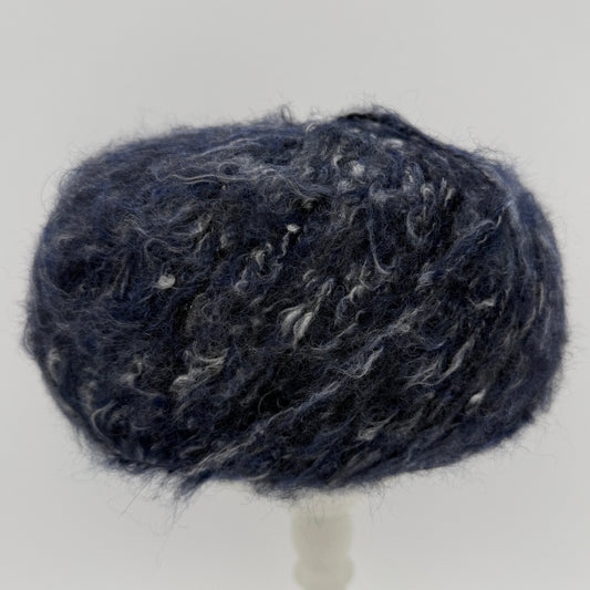 Mirasol Rit'i Aran Yarn color 06 Midnight Shadow, navy ball with white flecks
