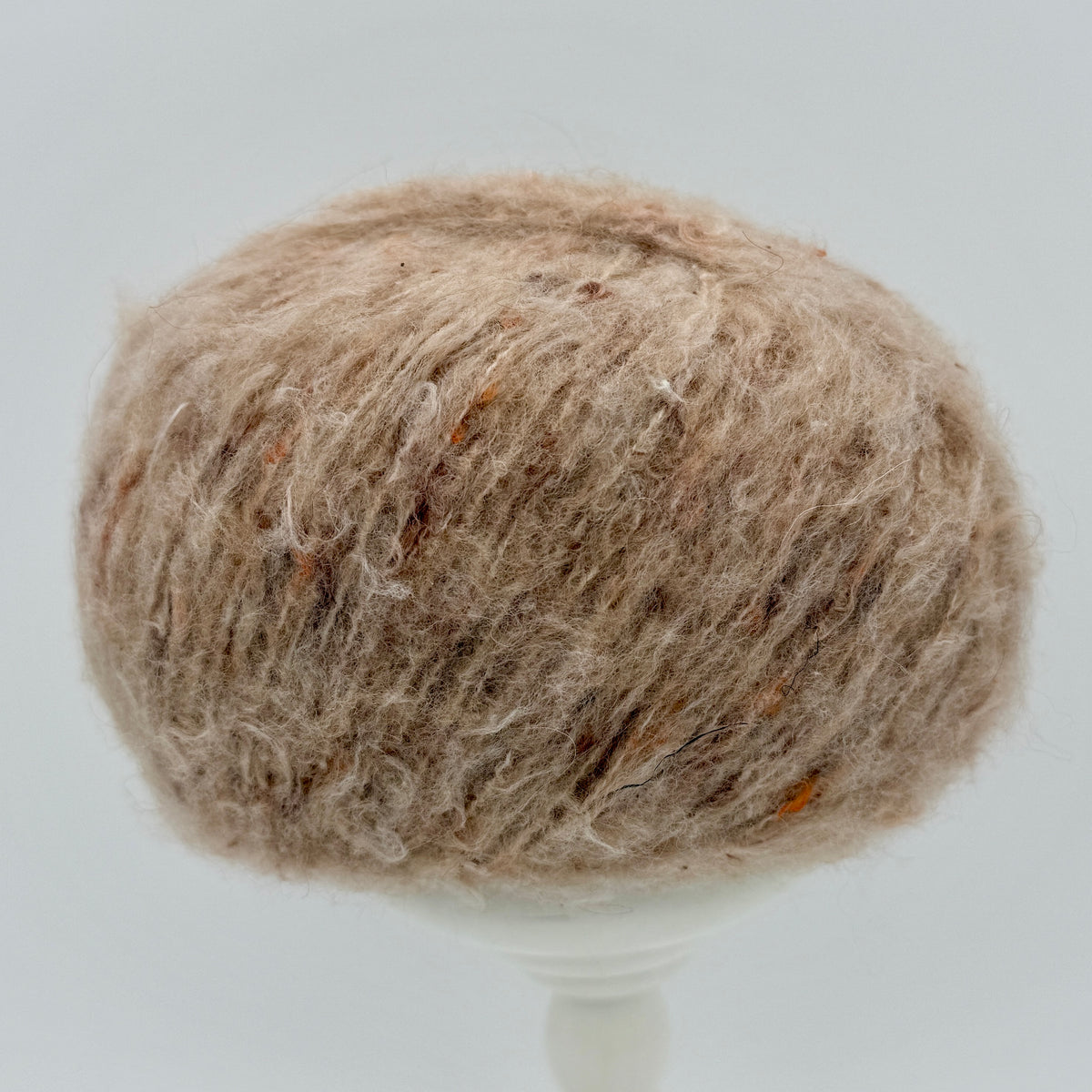 Mirasol Rit'i Aran Yarn color 04 Oat Ember, oatmeal tan ball with orange flecks