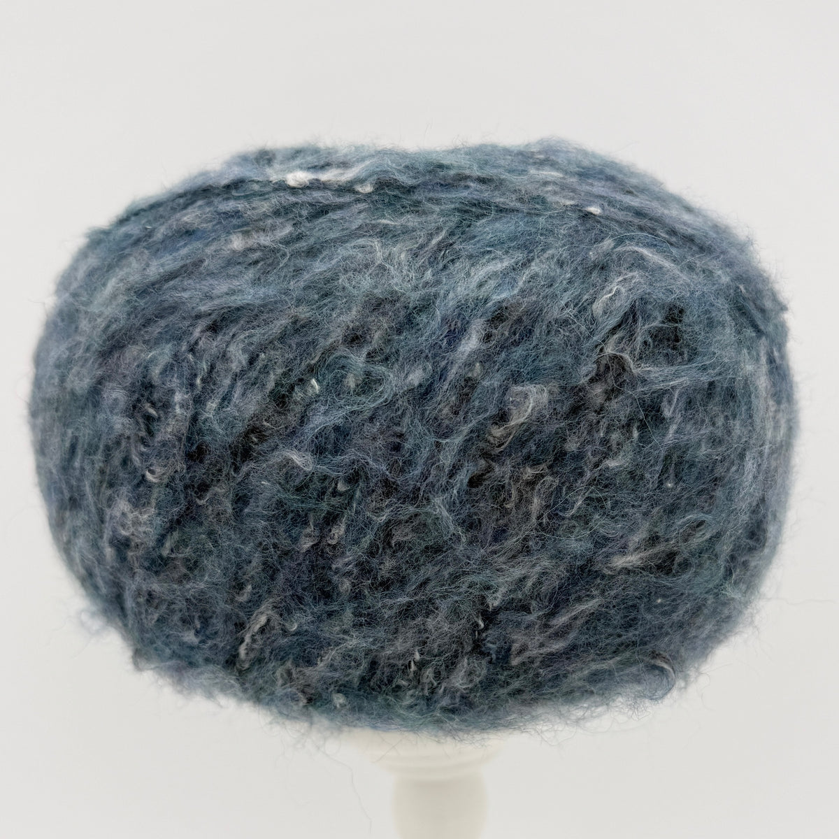 Mirasol Rit'i Aran Yarn color 05 Denim Sky, blue teal ball with a soft halo