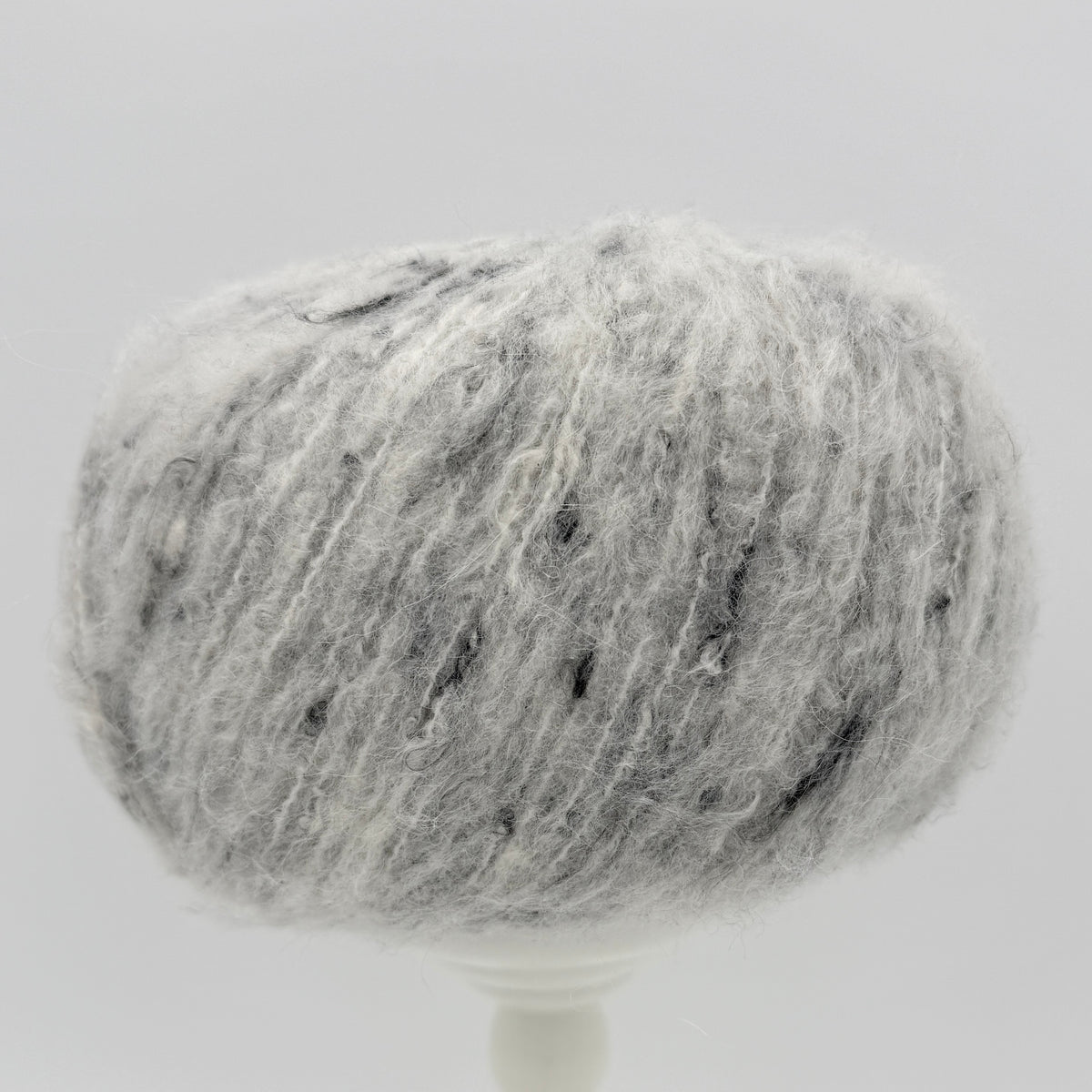 Mirasol Rit'i Aran Yarn color 02 Fleece Fog, pale grey ball with dark flecks