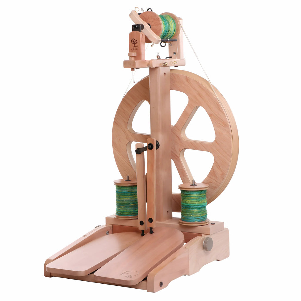 Wooden spinning wheel with green yarn on a white background