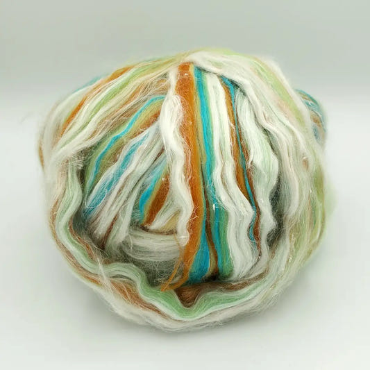 Ball of Pina Colada spinning fiber in cyan, orange, pale green and white