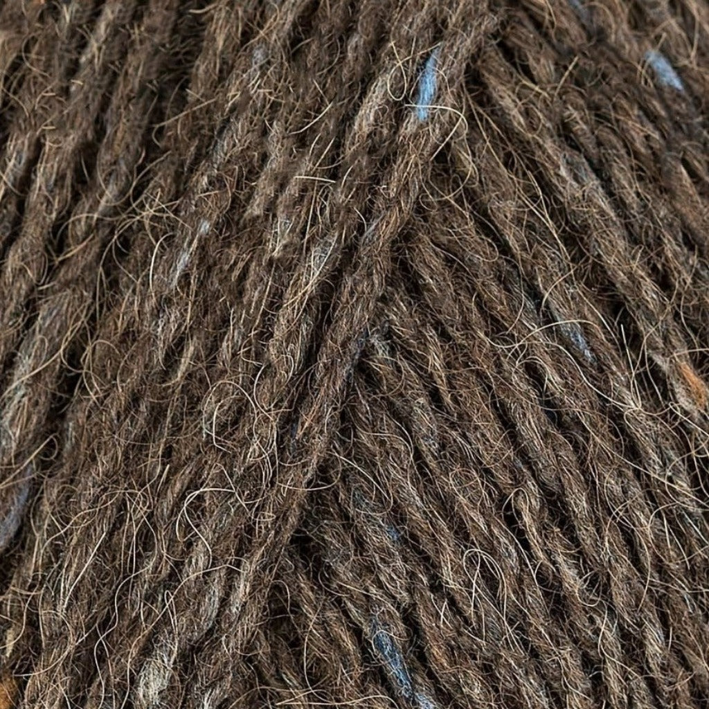 Phantom 153: A heathered tweed yarn in a medium brown color with flecks of cream and white.