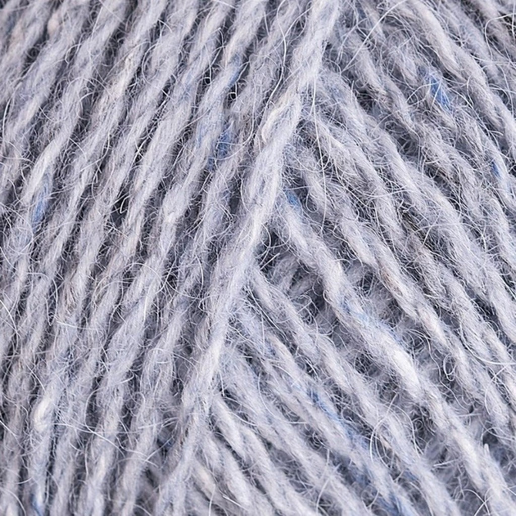 Scree 165: A heathered tweed yarn in a light grey color with flecks of blue and white.