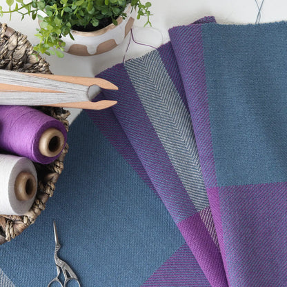 Woven cottolin cloth in blue and purple twill with cones and a shuttle