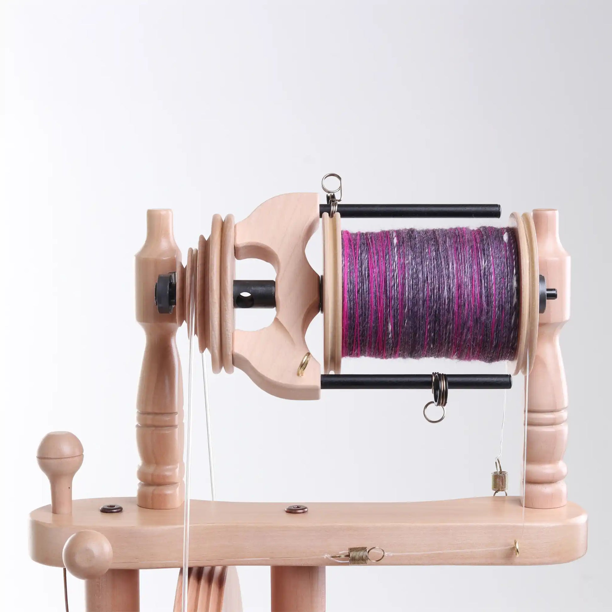 Wooden Traveller 3 bobbin with purple yarn on a white background