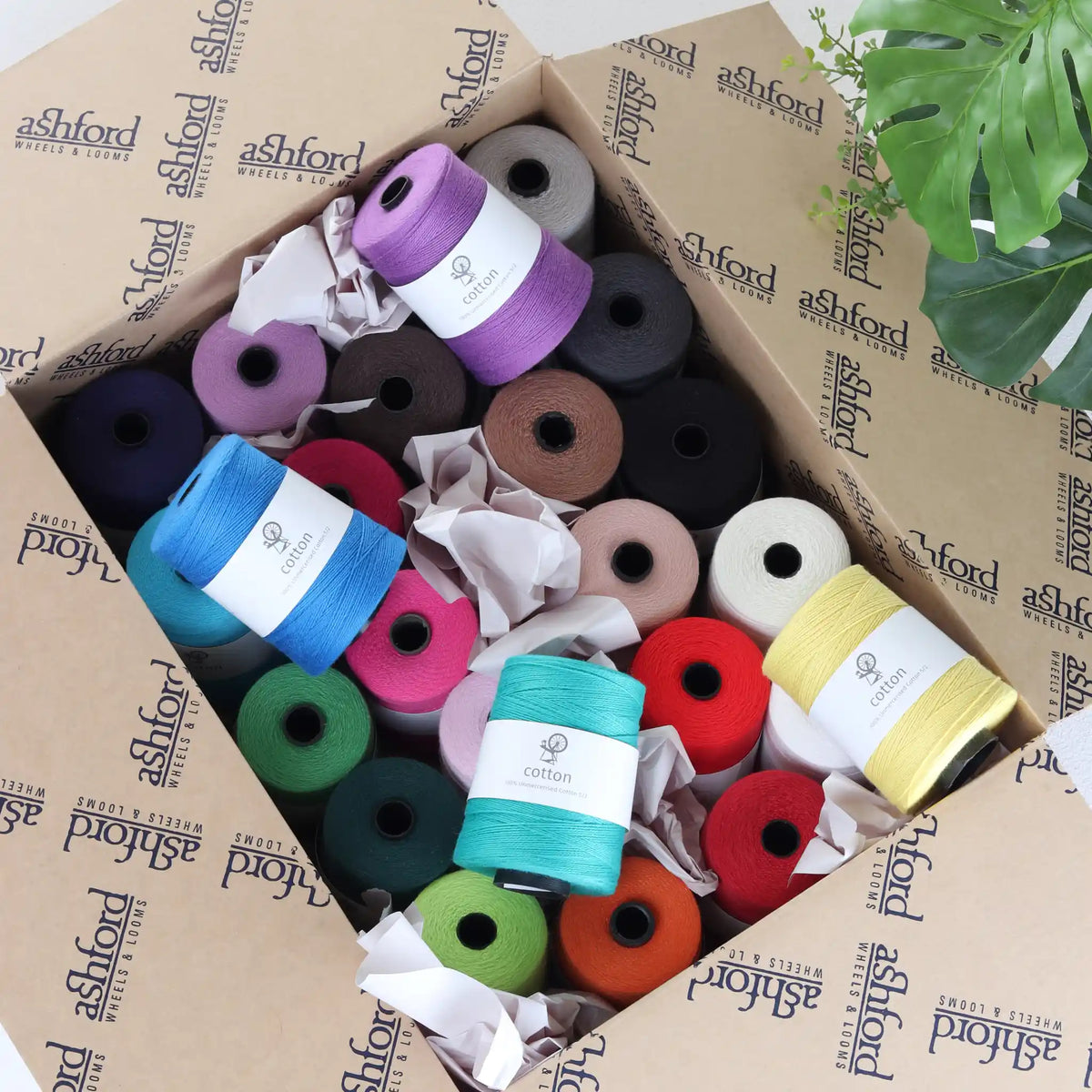 Box of Ashford 5/2 unmercerized cotton cones in mixed colors