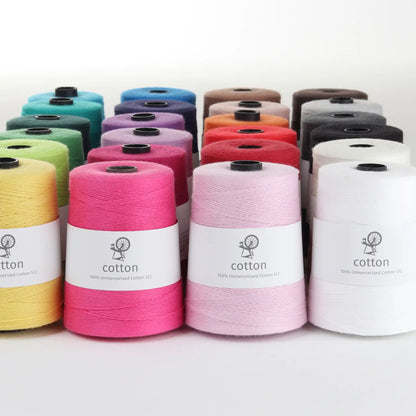 Ashford 5/2 unmercerized cotton cones in pink, yellow and white with the full color range behind