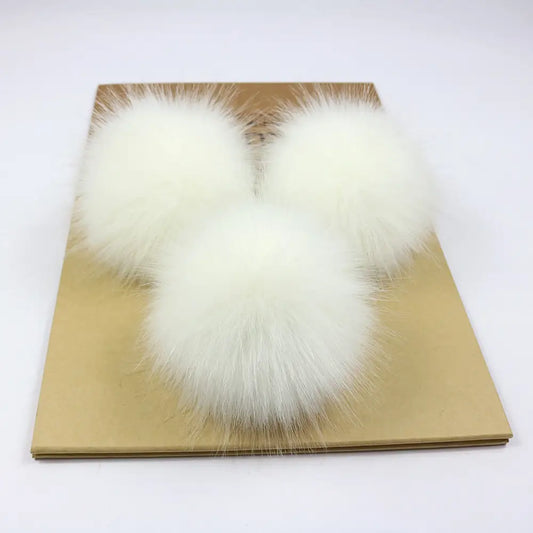 White fur pom-poms (ci_pom02) on brown background