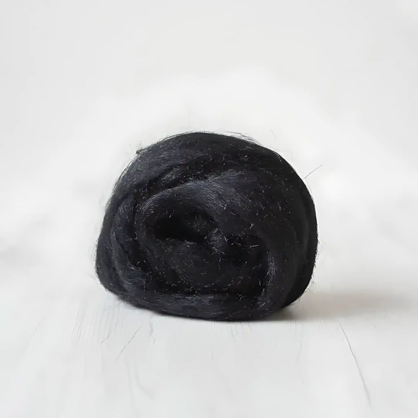 Coil of near-black charcoal Firestar nylon top sparkle fiber by Paradise Fibers