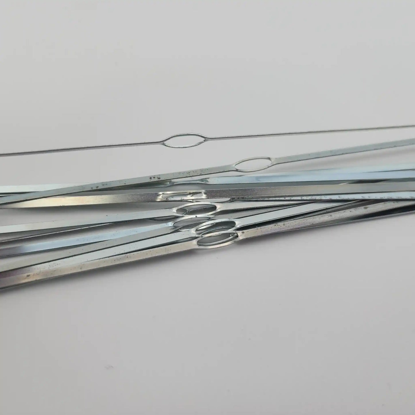Close view of the closed oval eye on a flat steel weaving heddle