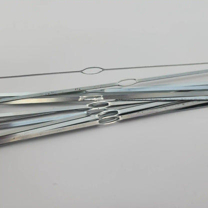 Close view of the closed oval eye on a flat steel weaving heddle