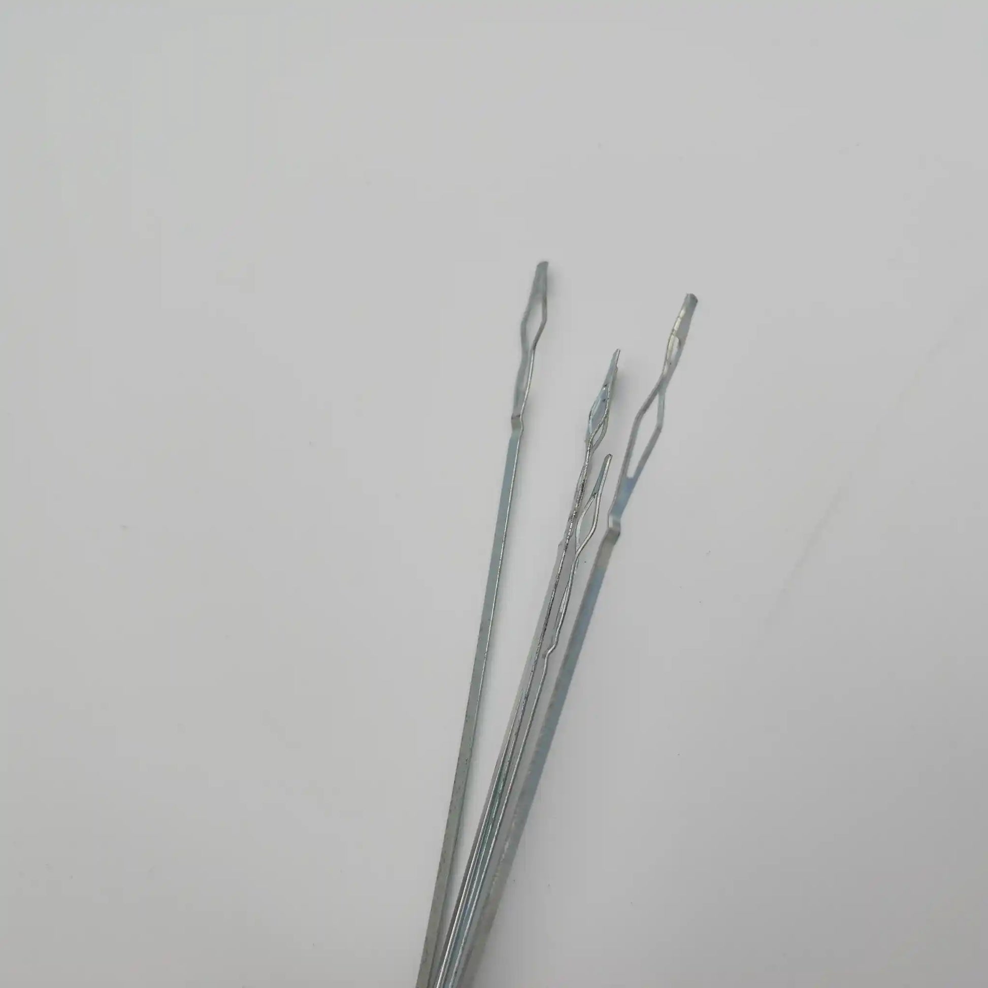 Close view of the sprung end loops on flat steel weaving heddles