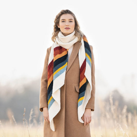 Gresham Wrap knit in Blue Sky Fibers Woolstok Worsted, ivory with seven color stripes, worn long over a camel coat