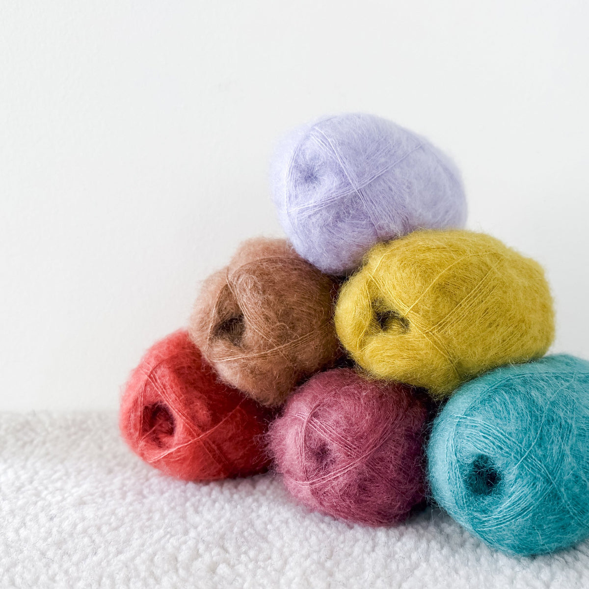 Kelbourne Woolens Harmony Lace Yarn, seven balls of kid mohair and silk lace yarn stacked in assorted colours
