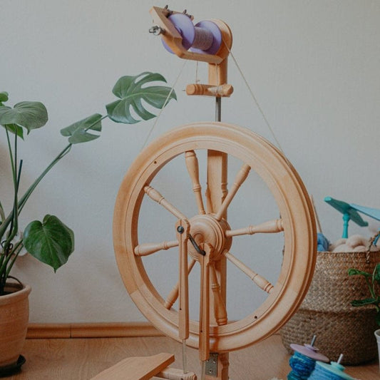 A Kromski Sonata Encore shown with a unique purple bobbin and yarn