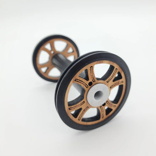 Majacraft Baby wood bobbin on its side, bamboo flange with black rim and white nylon bearing