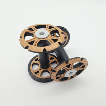 Two Majacraft Stylus bobbins side by side, showing the bamboo flange face and the black fibreglass barrel