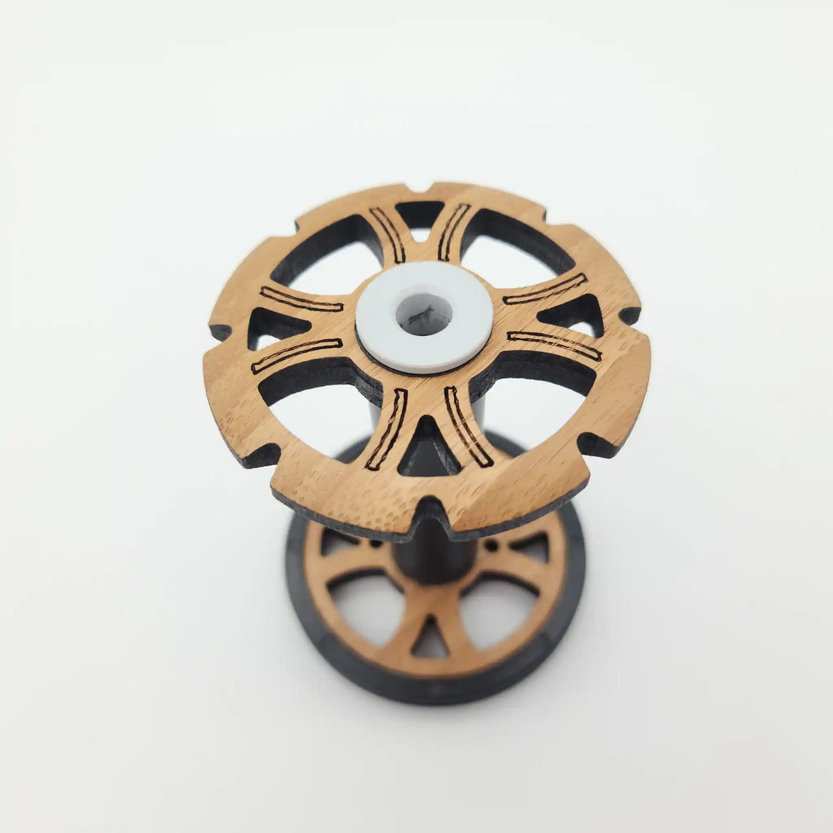 Majacraft Stylus bobbin seen from above, bamboo flange with black fibreglass core and white nylon bearing